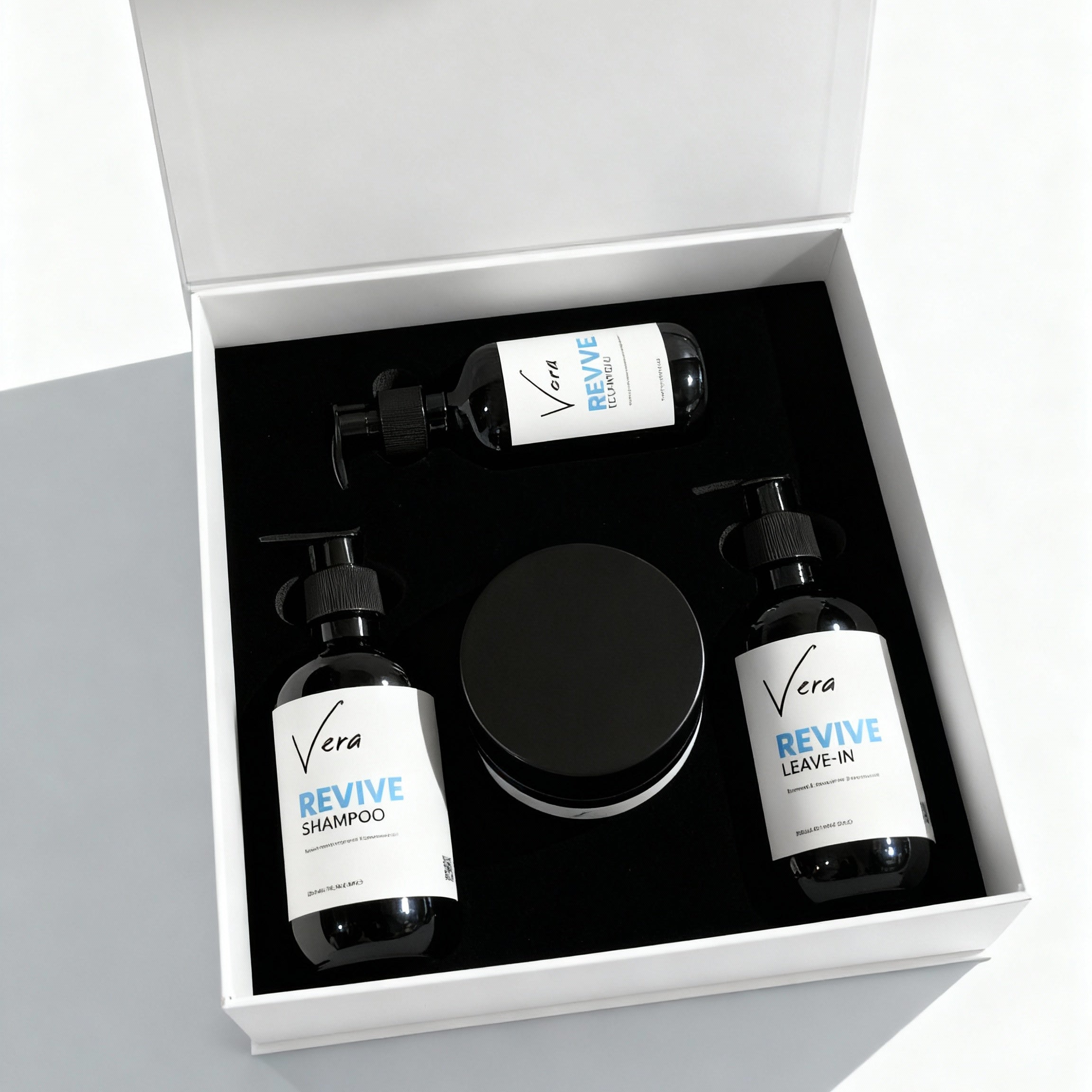 Hair_care_set_Hyper-realistic_studio_product_photo._Use_the_input_image_of_the_open_white_Vera_Revive_gift_box_with_black_interior_the_three_Revive_bottles_and_the_round_jar_inside_an_59f5636a-6235-4e0b-91f6-5961b442a1dd.jpg